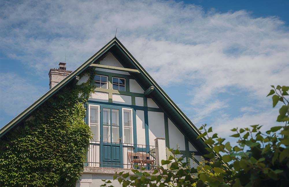 A man leans against a green SUV parked on the side of a desert highway.